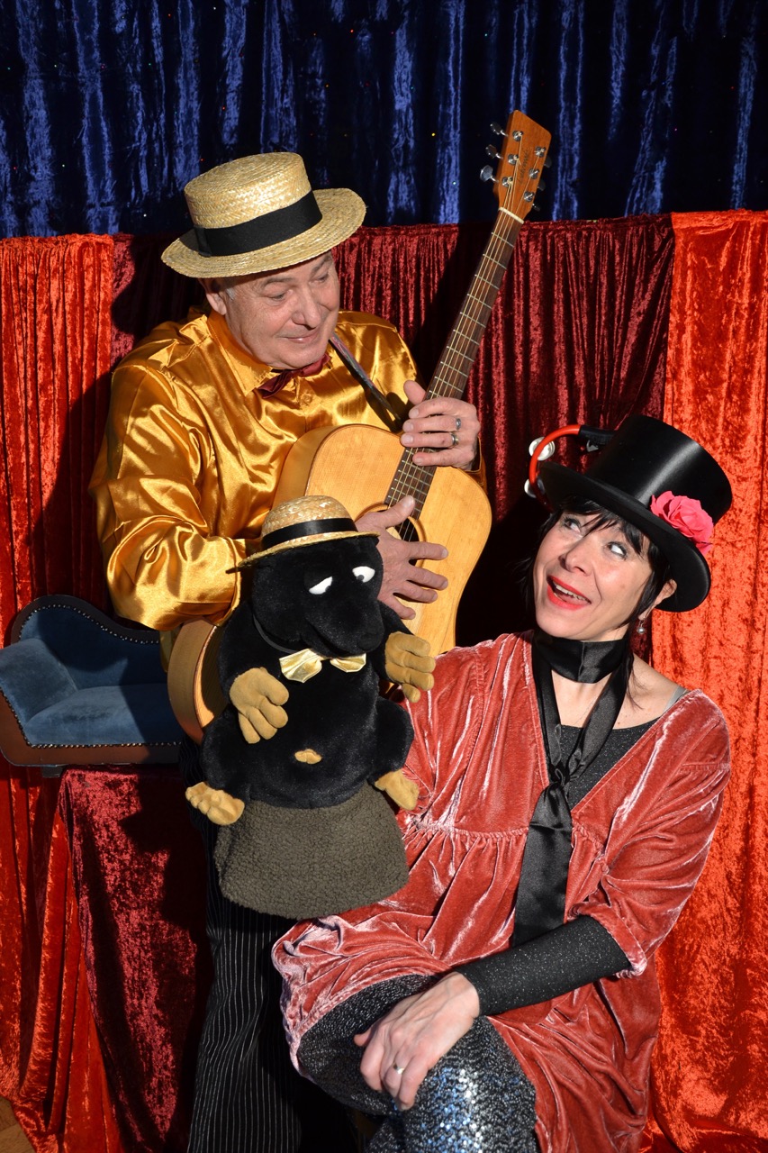 Die altmanns auf der Bühne vor rotem und blauem Vorhang mit Handpuppe Maulwurf