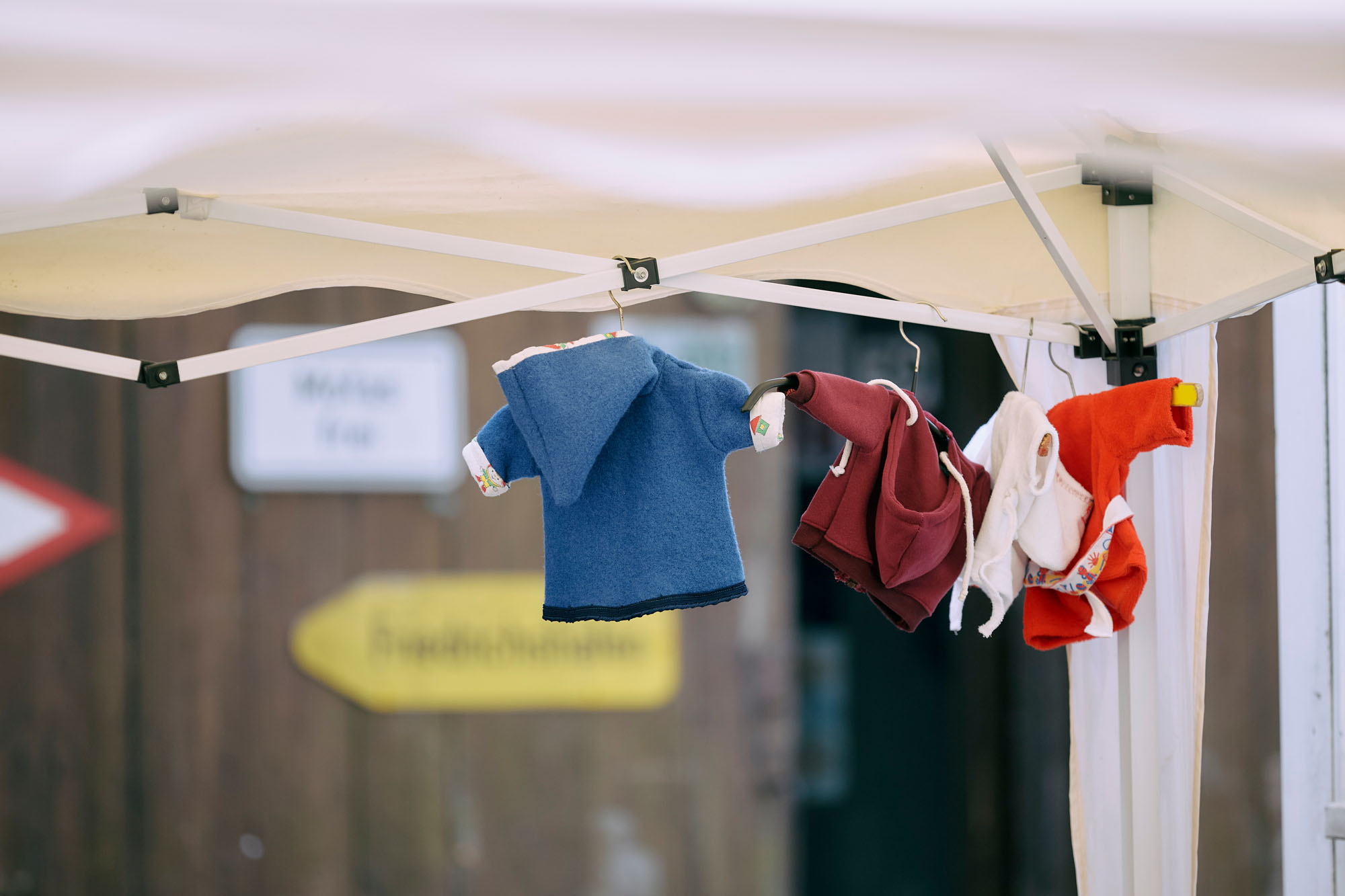 Kleinkinderkleider hängen zum Trocknen am Gestell eines Pavillions